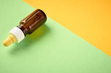 Burun damlaşişe kompozisyon, sarı ve yeşil arka plan üzerinde cam şişe