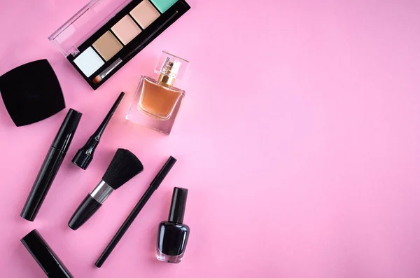 Different makeup products composition on pink background