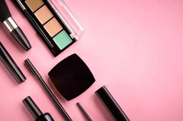 Diferentes productos de maquillaje composición sobre fondo rosa —  Fotos de Stock