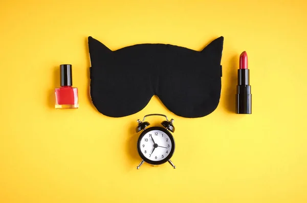 Black sleep mask with clock on yellow background composition, cat mask with ears