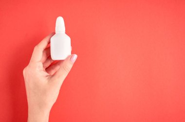 El ile Burun sprey şişe kompozisyon, pembe arka plan üzerinde beyaz şablon şişe