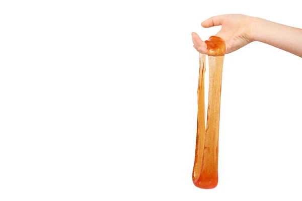 Criança jogando lodo laranja com a mão, brinquedo transparente — Fotografia de Stock