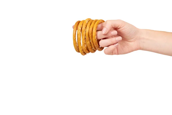 Hand with dried bagel, fresh baked bun, fast food snack. — Stock Photo, Image