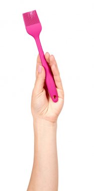 Pembe mutfak fırçasıyla el.