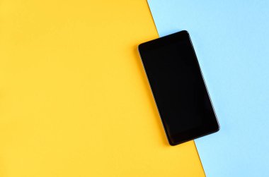 Siyah cep telefonu sarı ve mavi arka plan kompozisyonu, cep telefonu.