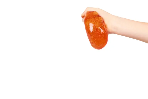 Criança jogando lodo laranja com a mão, brinquedo transparente — Fotografia de Stock