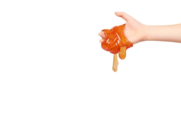 손으로, 투명 한 장난감 오렌지 점액을 재생 하는 아이 — 스톡 사진