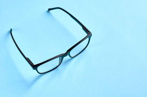 Gafas negras sobre fondo azul composición, gafas graduadas . — Foto de Stock