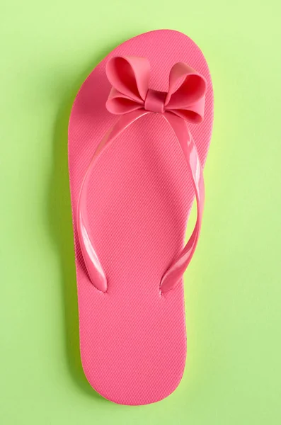 Zapatillas de goma rosa sobre fondo verde composición . — Foto de Stock