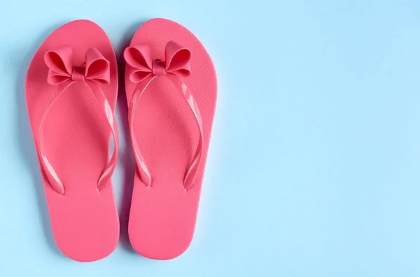 Zapatillas de goma rosa sobre fondo azul composición . — Foto de Stock