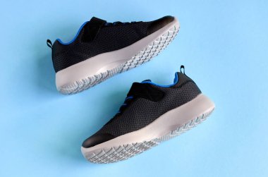 Mavi arka plan kompozisyonu üzerine spor ayakkabılar, koşmak için ayakkabılar.