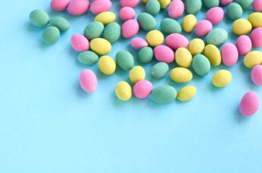 Renkli tatlılar, mavi arka plan kompozisyon üzerinde sır ile kaplı fıstık.