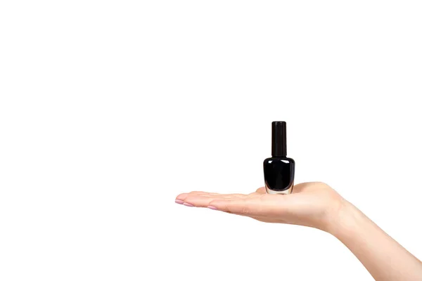 Ręka z czarną butelką do paznokci, piękno i Pielęgnacja. — Zdjęcie stockowe