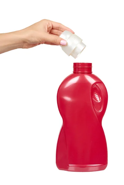Mão com garrafa de detergente vermelho, sabão de lavagem líquido para têxteis . — Fotografia de Stock