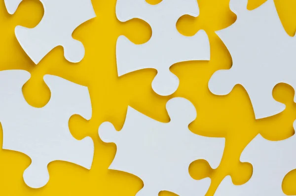Composição de puzzles brancos no fundo amarelo. Depósito plano — Fotografia de Stock