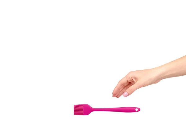 Mão com pincel culinário rosa, utensílio de cozinha . — Fotografia de Stock