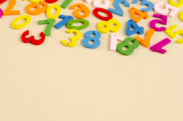 Números de madera de color composición sobre fondo beige . — Foto de Stock