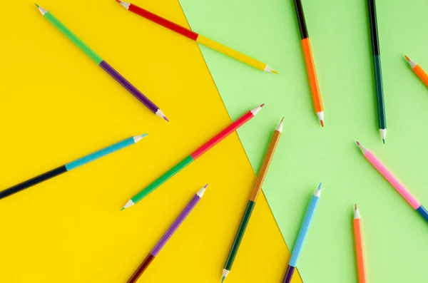 Composição de lápis coloridos em fundo amarelo e verde . — Fotografia de Stock