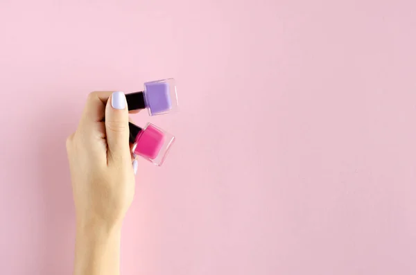 Mano con composición de esmalte de uñas de color en backgorund rosa . — Foto de Stock