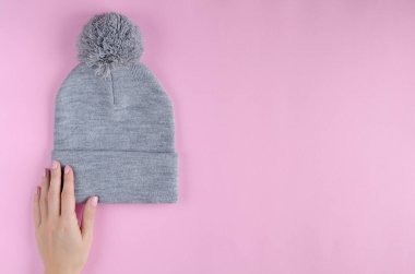 Pembe arka planda gri pamuklu şapka kompozisyonu.