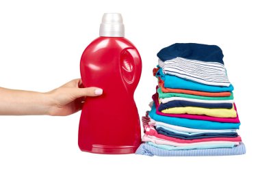 Giysi ve deterjan şişesi, taze çamaşır tekstili yığını ile el.