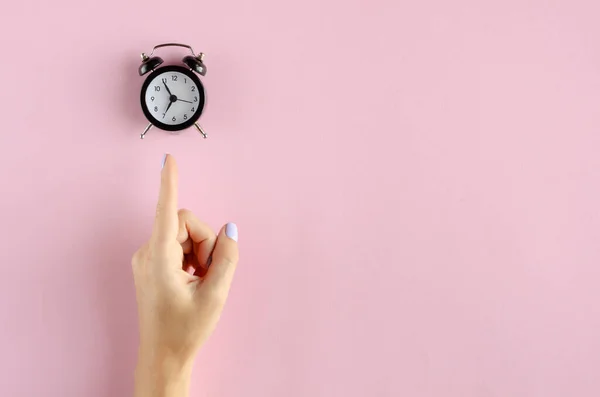 ピンクの背景にアナログ目覚まし時計組成と手. — ストック写真