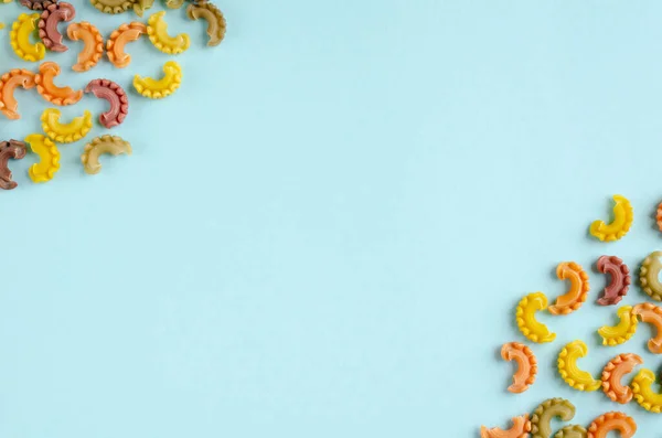 Gekleurde pasta compositie op blauwe achtergrond. Vlakke plaat — Stockfoto