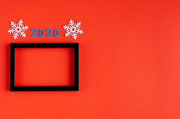 Número 2020, copos de nieve blancos y composición de marco de madera negro sobre fondo rojo, Año Nuevo y vacaciones de Navidad . —  Fotos de Stock