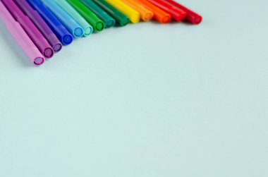 Mavi arkaplanda renkli keçeli kalem bileşimi.