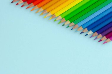 Mavi arka planda renkli kalemler kompozisyonu. Düz yatıyordu.