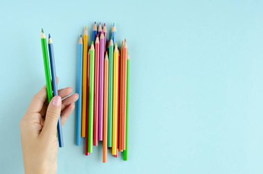 Mavi arkaplanda renkli kalem kompozisyonu.