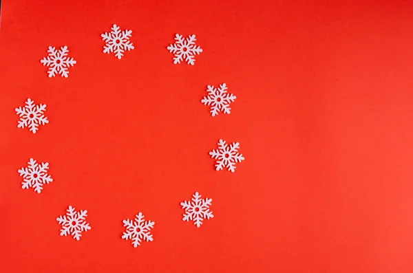 Composición de copos de nieve blancos sobre fondo rojo, Año Nuevo y vacaciones de Navidad . — Foto de Stock