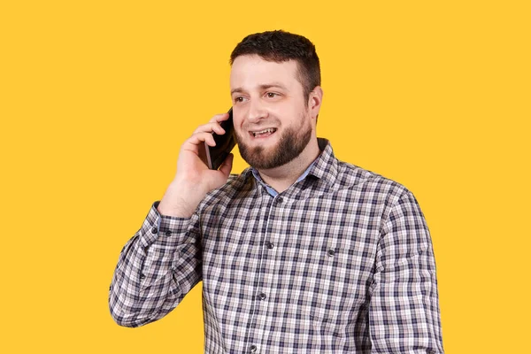 Gülümseyen ve cep telefonu kullanan bir adam. Beyaz arkaplanda izole.