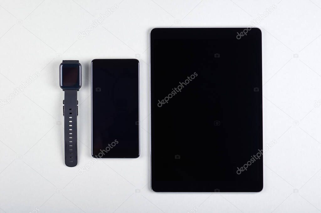 Different mobile gadgets, cellphone, tablet and smart watches on grey background. Flat lay, overhead view image.