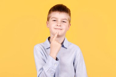 Esmer bir çocuğun portresi işaret ediyor, fikir kavramı, düşünce. Sarı arkaplanda izole edilmiş.