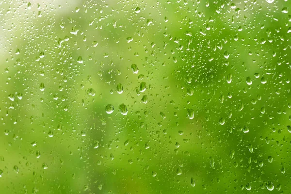 Raindrops on a window pane, green transparent background.