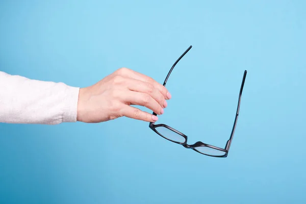 Lunettes Dans Une Main Sur Fond Bleu — Photo