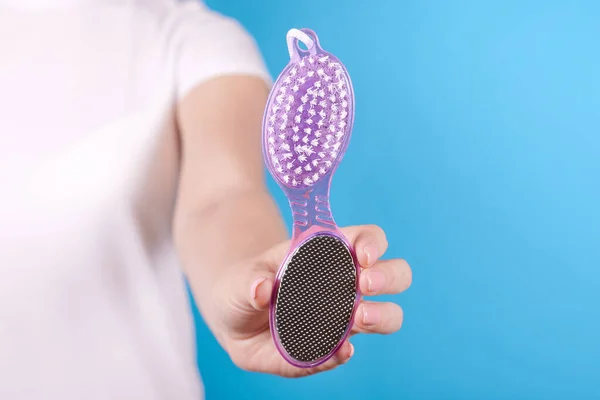 Hand with foot scrub, sole peeling tool.