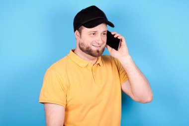 Siyah şapkalı esmer adam cep telefonu kullanıyor..