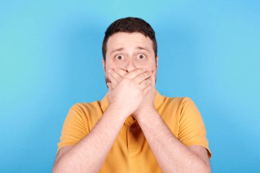 Esmer adam korkmuş, ellerini ve ağzını tutmuş..