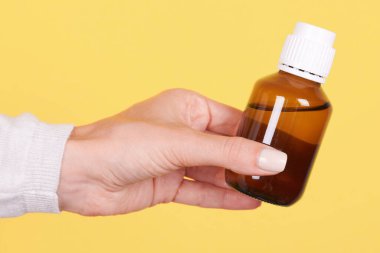 İlaç şişesi ve kimya kabıyla el..