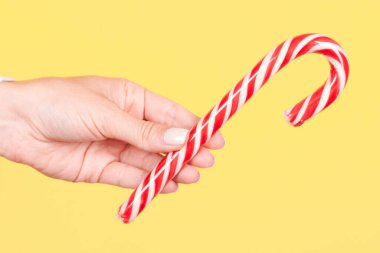 Kırmızı çizgili şeker kamışlı el..