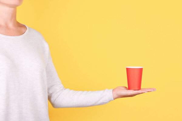Hand with red disposable cup.