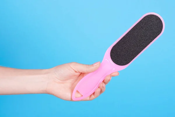 Hand with foot scrub, sole peeling tool.
