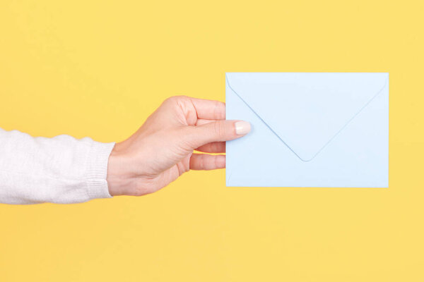 Hand with blue paper envelope.