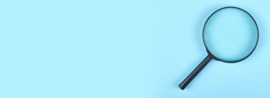 Mavi arkaplanda siyah büyüteç.