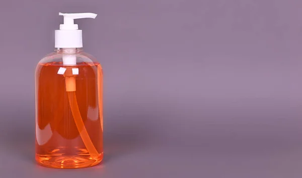 灰色の背景にオレンジの液体石鹸のボトル 高品質の写真 — ストック写真