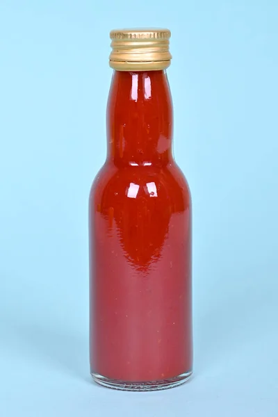 Hot Red Chilly Sauce Little Glass Bottle Blue Background High — Stock Photo, Image