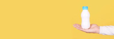 Elinde yoğurt olan beyaz şişe..