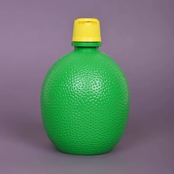 Συγκεντρώστε Χυμό Λεμονιού Ένα Πράσινο Μπουκάλι Ένα Γκρι Φόντο Υψηλής — Φωτογραφία Αρχείου